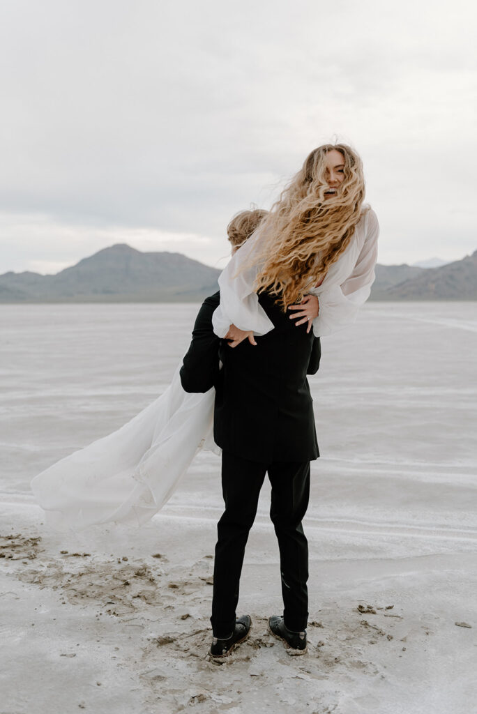 playful bride and groom at bonneville salt flats