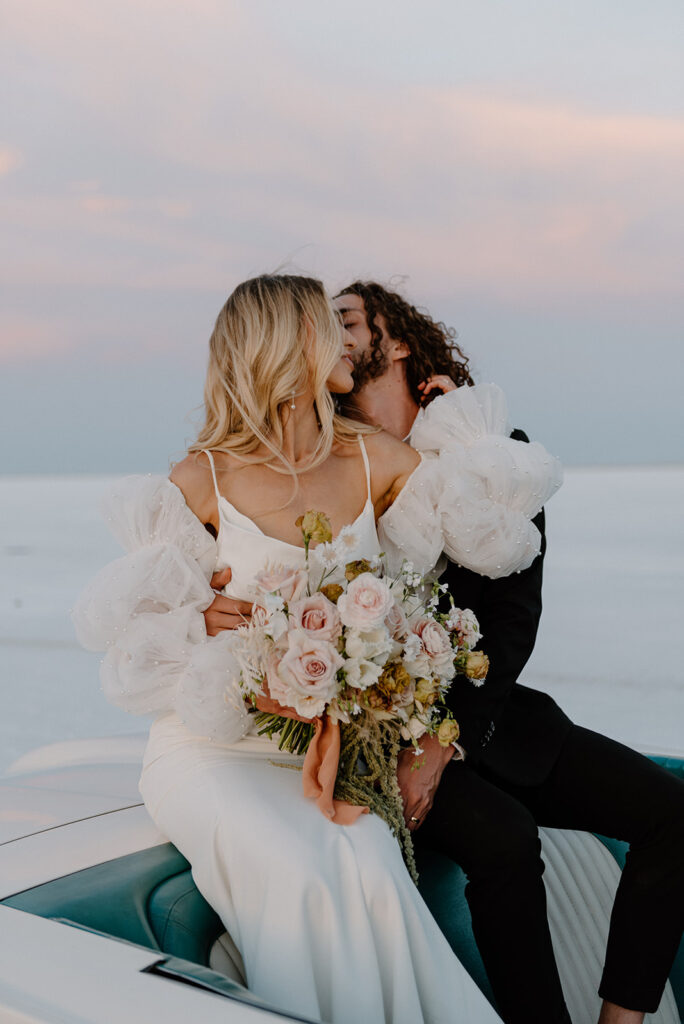 a romantic bride and groom with a vintage car during their bonneville salt flats elopement