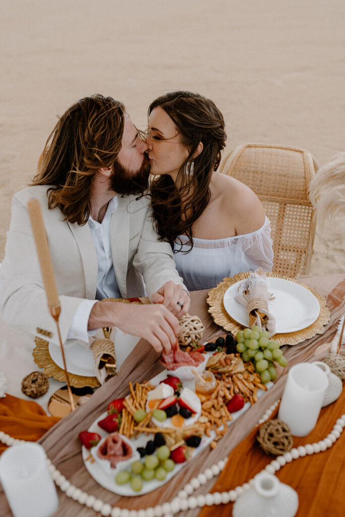 couple enjoying a charcuterie board during their boho Outer Banks elopement day