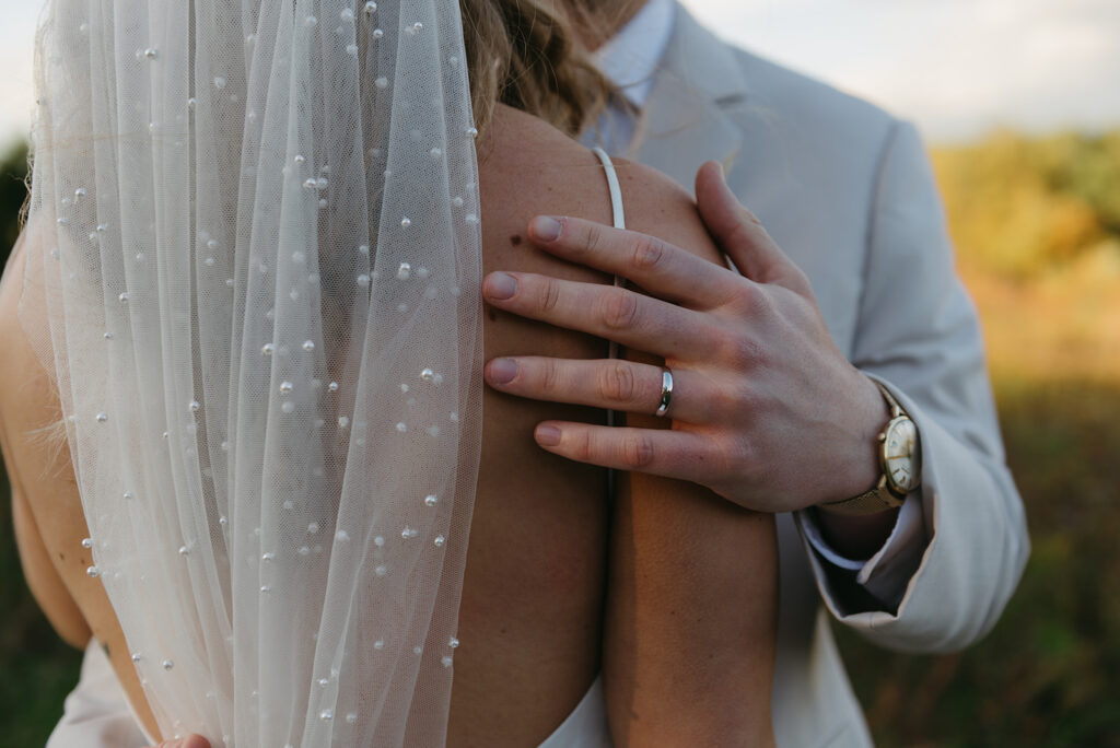 close up of groom hugging his bride