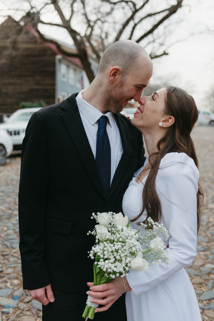 elegant elopement couple standing on a cobblestone street during their winter old town alexandria wedding elopement