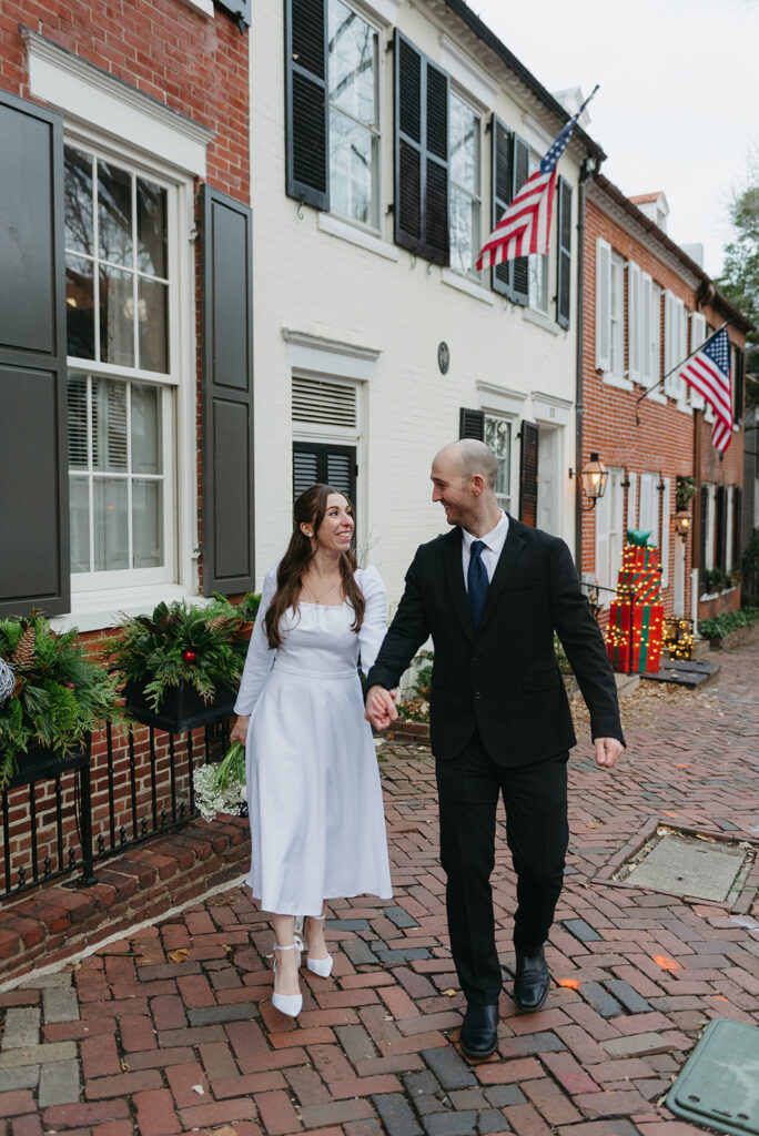 elegant elopement couple standing on a cobblestone street during their winter old town alexandria wedding elopement