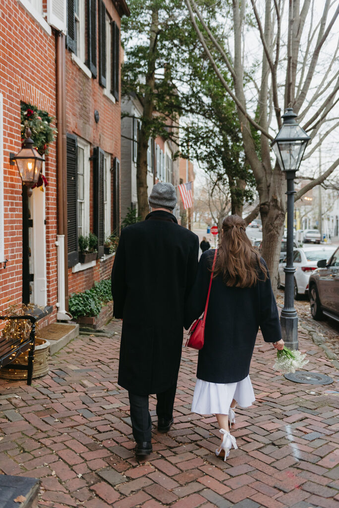 elegant elopement couple standing on a cobblestone street during their winter old town alexandria wedding elopement