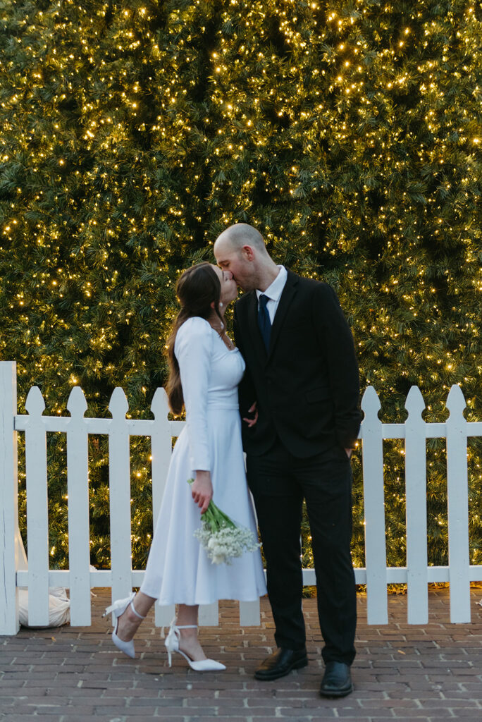 winter elopement in an old city with a sparkling christmas tree in the background